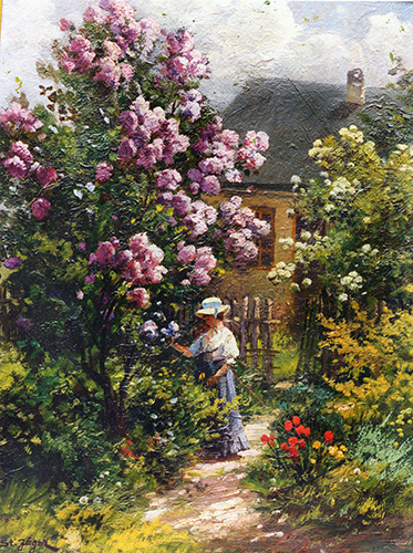 Dame im Garten beim Fliederstrauch